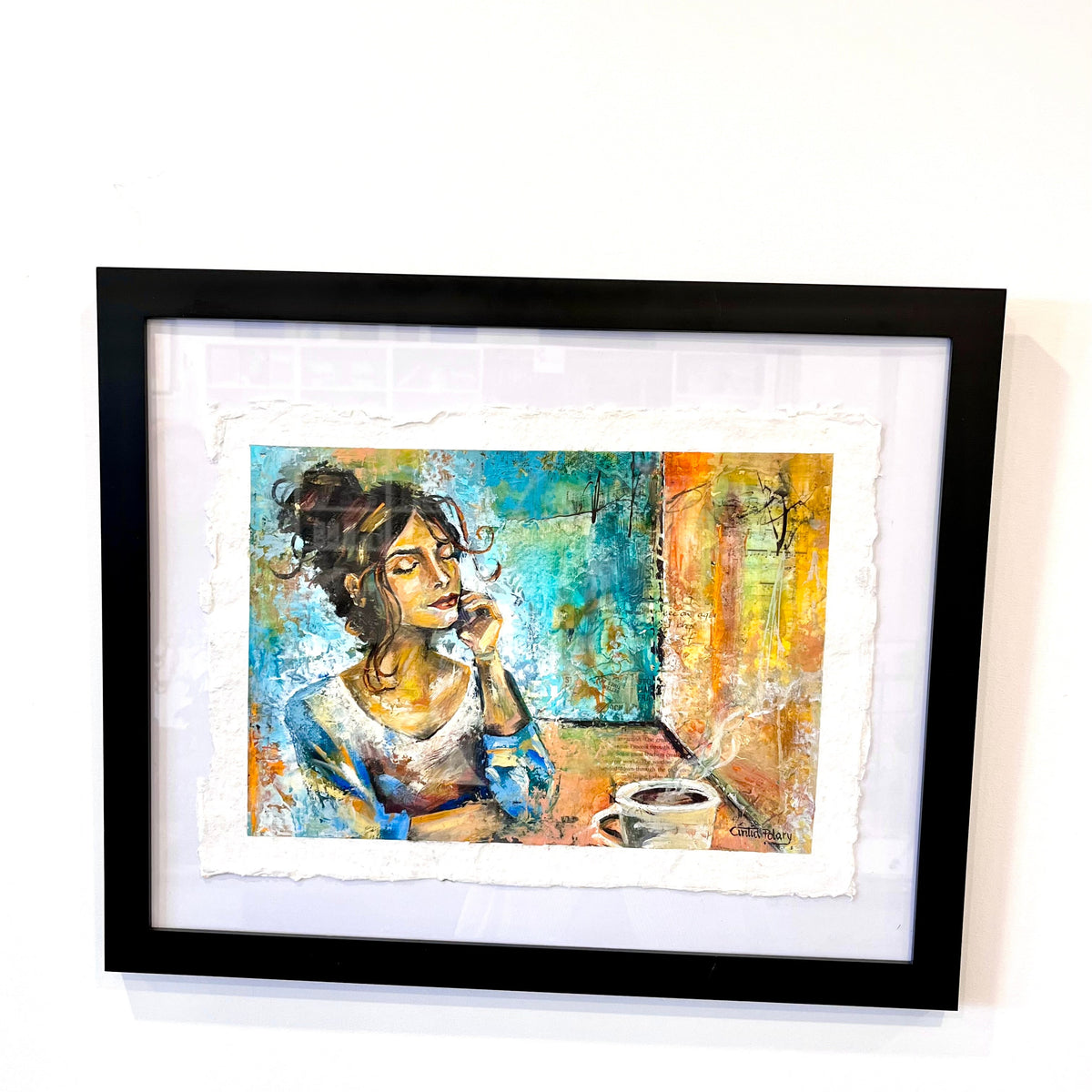 A framed art print featuring an expressive, textured painting of a woman in a blue and orange-toned interior, displayed in a black frame with a white mat against a plain white wall.
